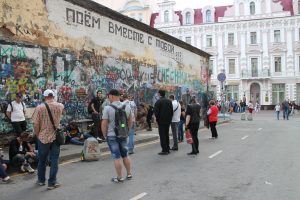 Tsoi Wall in Moscow, June 2018; a wall with graffiti, people looking closely at the wall